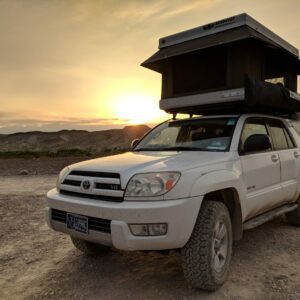 A white truck with an open roof on top of it.