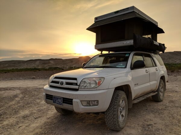 A white truck with an open roof on top of it.