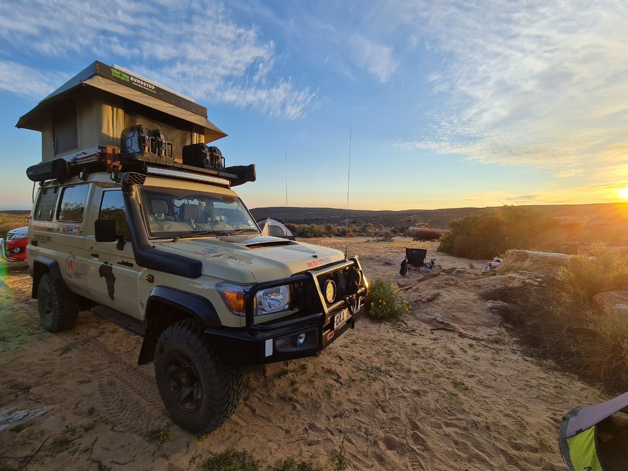 A truck parked on top of a sandy beach.