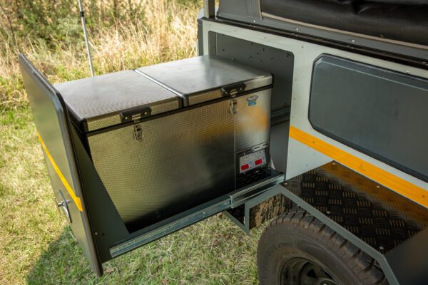 A large metal box is attached to the side of an off road vehicle.