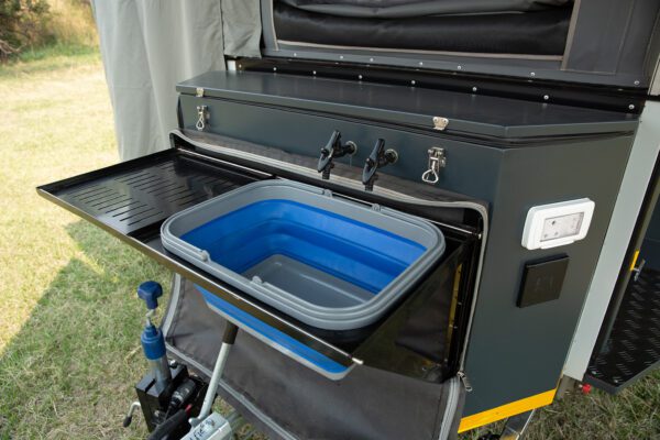 A black and blue cooler sitting on top of an outdoor table.