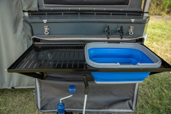 A grill with an open lid and a blue tub.