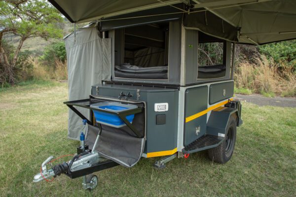 A small trailer with an awning and storage compartment.