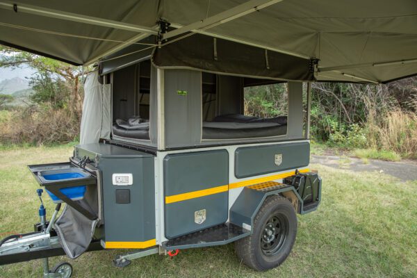 A small trailer with an awning over it.