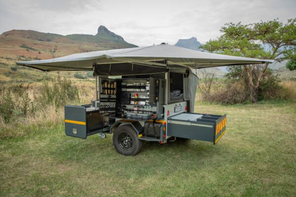 A trailer with an awning and storage compartments.