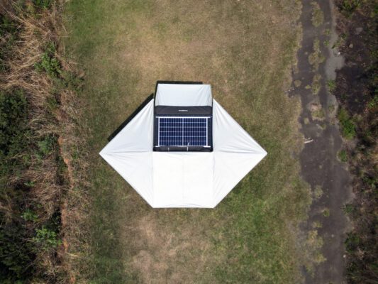 A solar panel sitting on top of an umbrella.