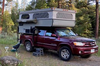 A truck with an rv on top of it.