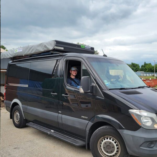 A man sitting in the drivers seat of a van.