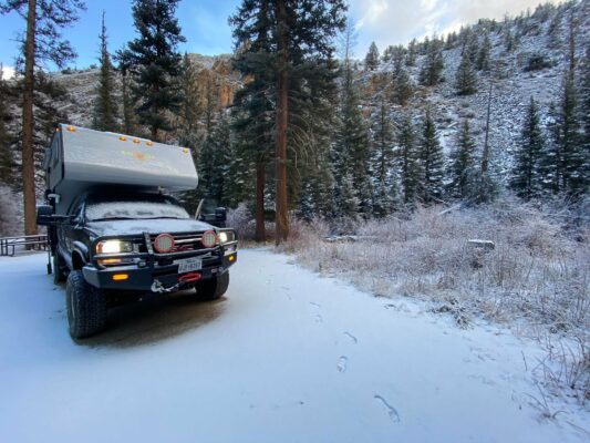 A truck driving down the road in the snow.