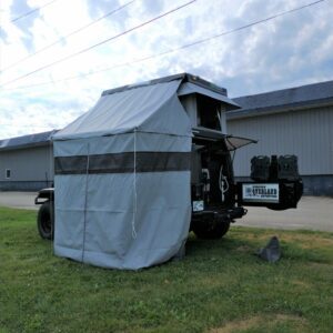 A truck with a tent on the back of it.