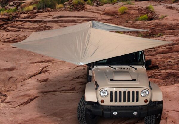 A jeep with an umbrella attached to it.