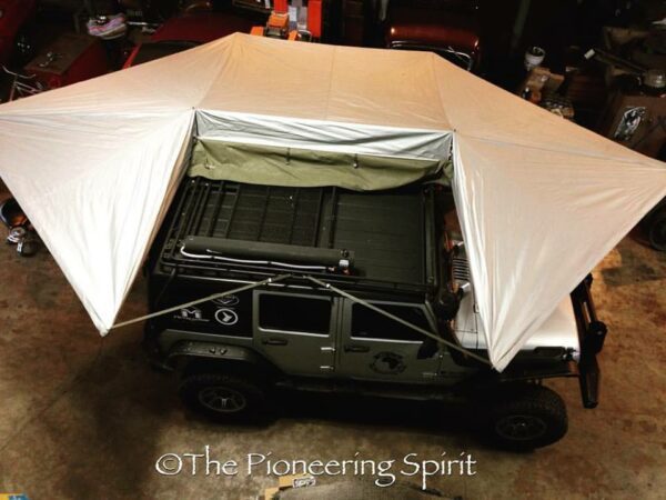 A jeep is covered with an umbrella over it.