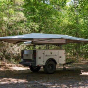 A camper trailer with an awning attached to it.