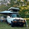 A white truck with an awning on top of it.