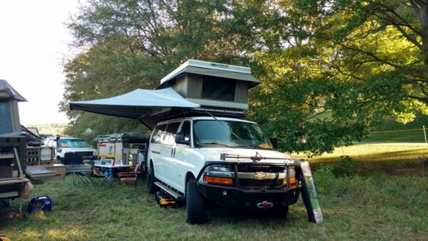 A white truck with an awning on top of it.