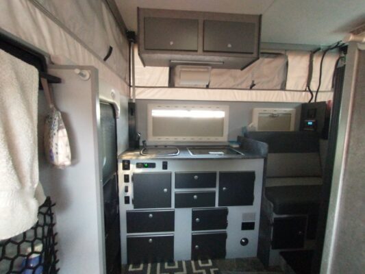 A kitchen with black and white cabinets and a stove.