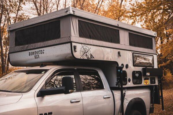 A truck with an rv on top of it.