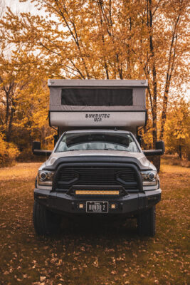 A truck with an open camper on the back.