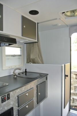 A kitchen with a sink and mirror in it