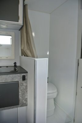 A bathroom with a sink, toilet and mirror.