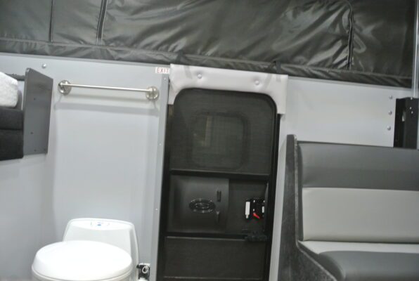 A toilet and sink in the back of an rv.