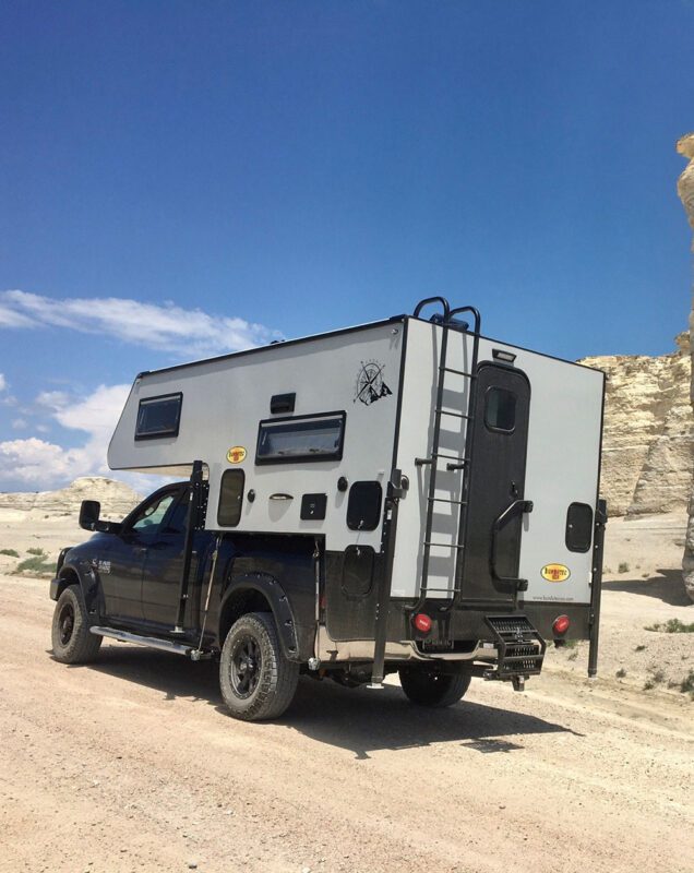 A truck with an rv on the back of it.