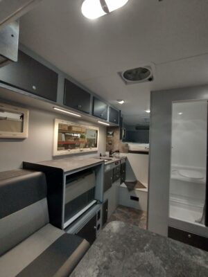 A kitchen with a sink, refrigerator and microwave.