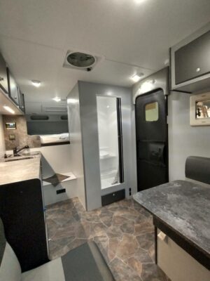 A kitchen with a sink, refrigerator and microwave.