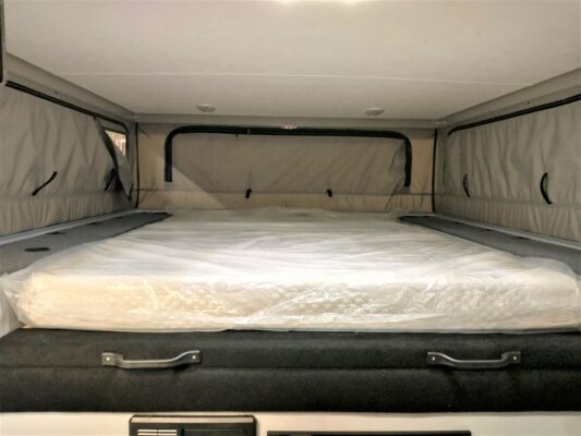 A bed in the back of an rv.