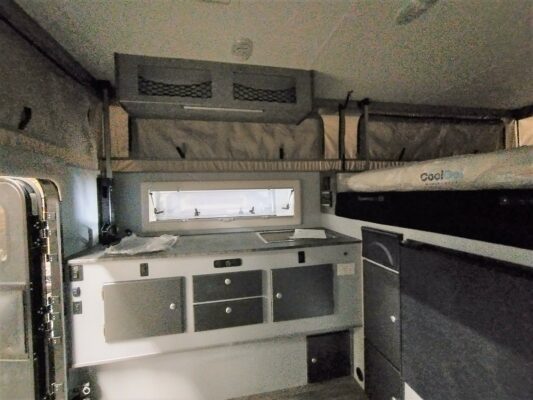 A kitchen area with sink, oven and refrigerator.