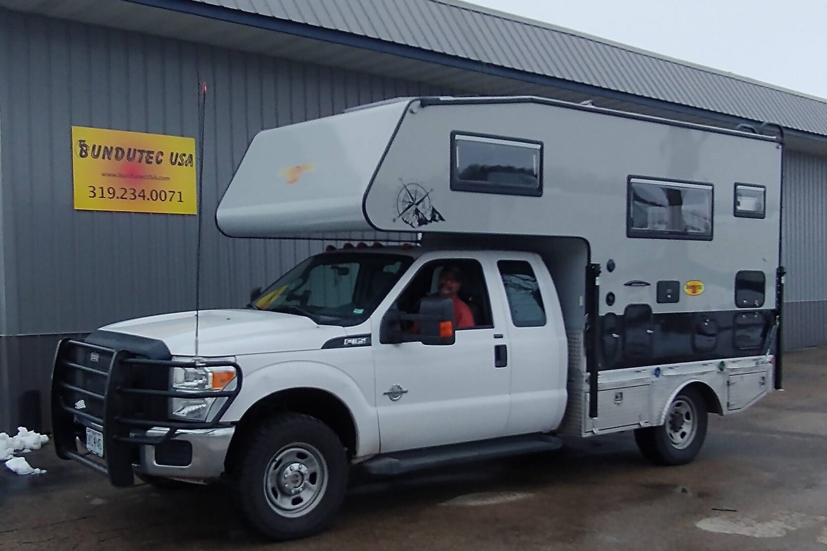 A truck with an rv in the back of it.