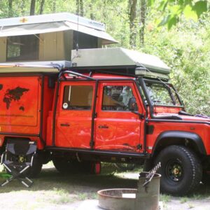 A red truck with an open tent on top.