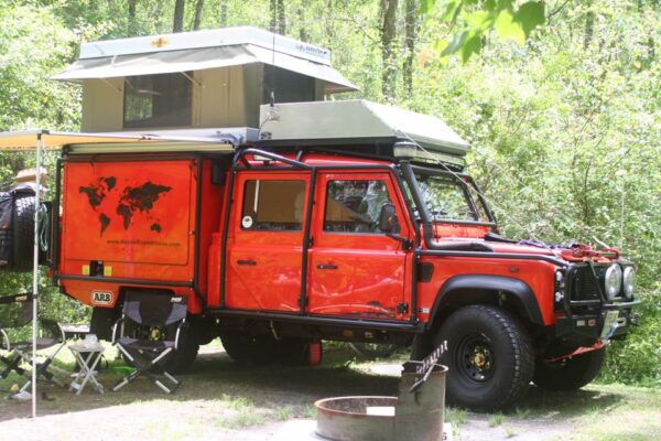 A red truck with an open tent on top.