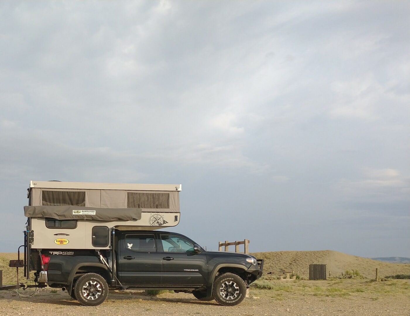 A truck with an rv on top of it.