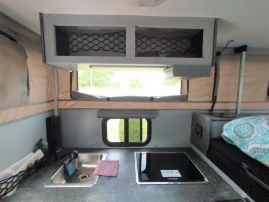 A kitchen area with sink, stove and window.