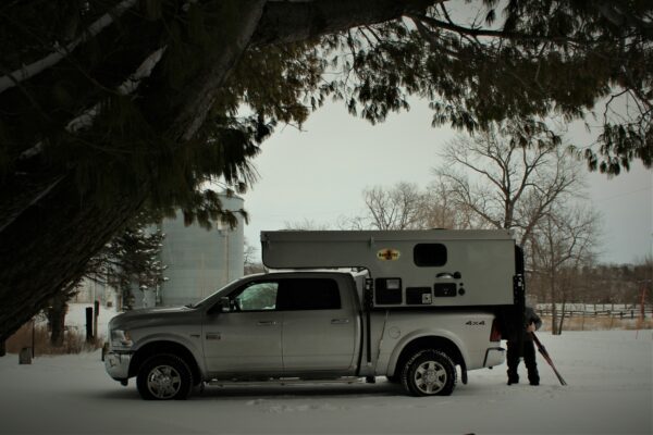 A truck with an rv in the back of it.