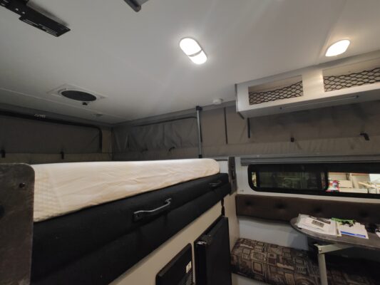 A bed in the back of an rv.