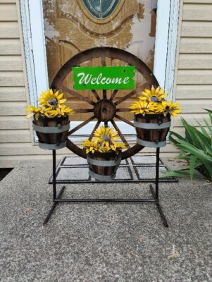 A wheel with three flower pots on it.