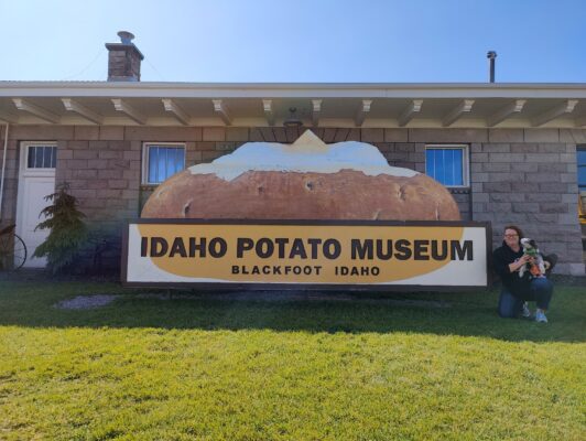 A person standing in front of a sign that says idaho potato museum.