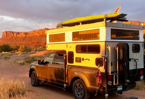 A truck with a camper on top of it.