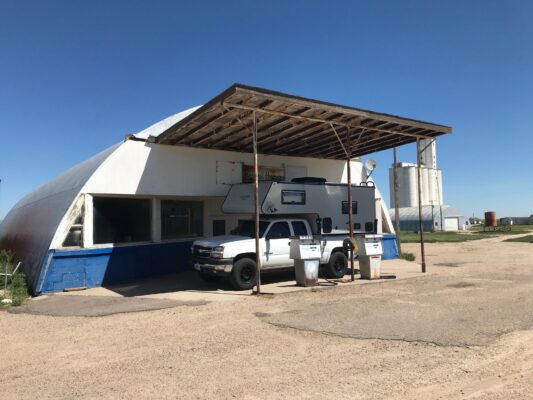 A gas station with a truck parked in front of it.