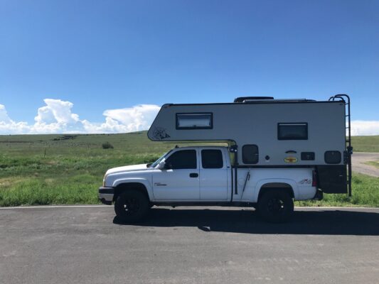 A white camper parked on the side of a road.