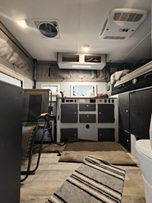 The interior of an rv with a toilet and sink.