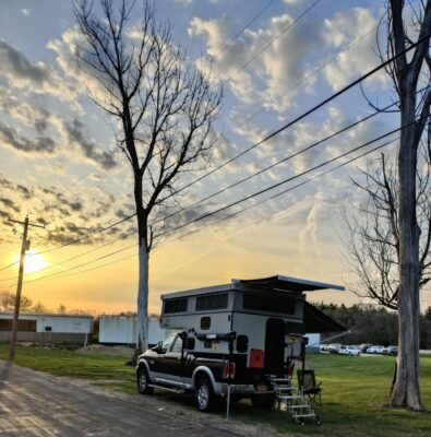 An rv parked on the side of a road with trees in the background.