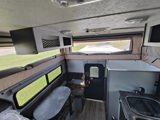 The interior of an rv with a kitchen and sink.