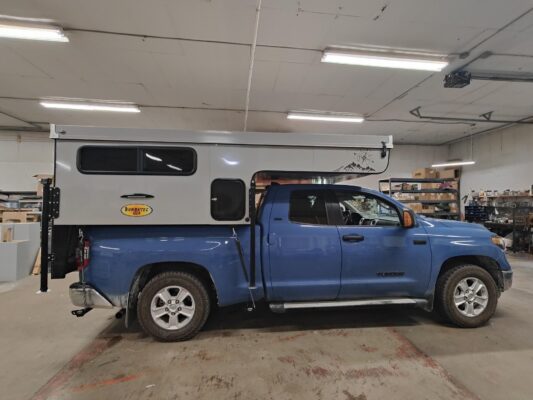 A toyota pickup truck with a camper attached to it.