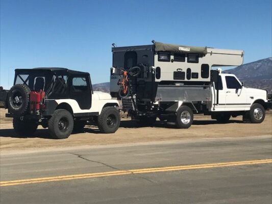 A jeep with a camper attached to it.