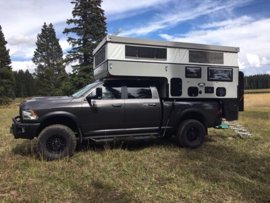 A ram truck with a camper on top of it.