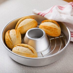 A baking rack with rolls in it.