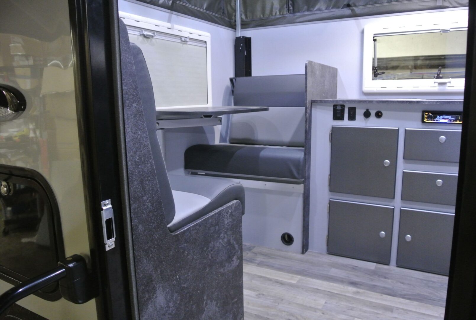 The inside of an rv with a desk and chairs.